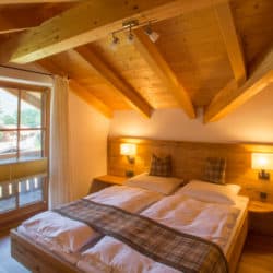 Ferienhaus "BergZeit" - Schlafzimmer mit Doppelbett in Übergröße